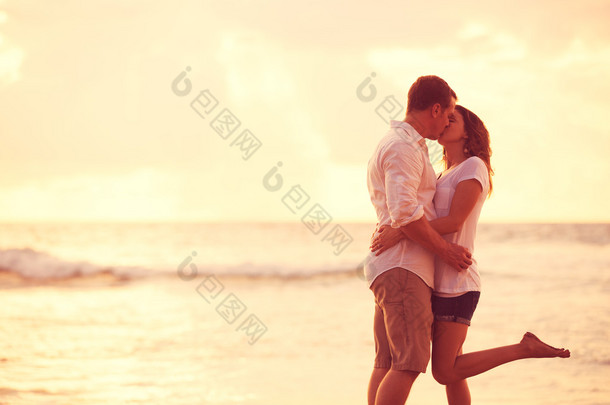 <strong>浪漫</strong>的情侣在沙滩上亲吻日落时分