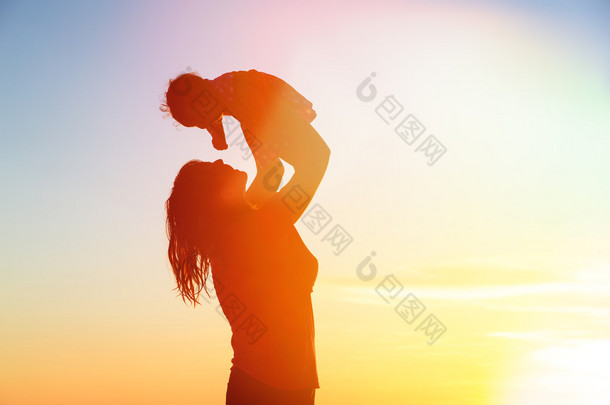 快乐妈妈和宝宝在日落海滩玩