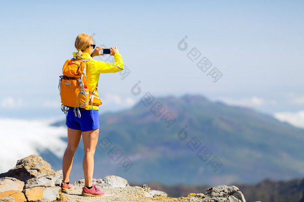 女人的徒步旅行者在山拍照