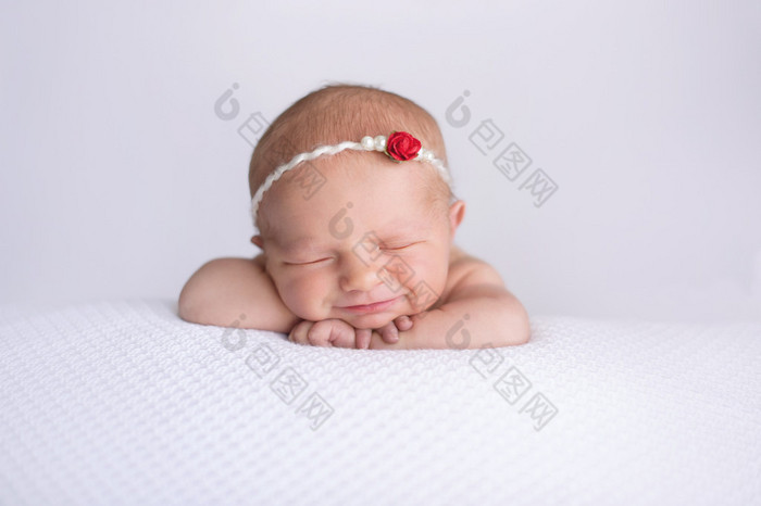 微笑着刚出生的婴儿女孩穿着红色的玫瑰头带