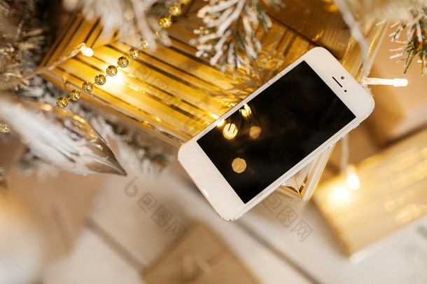 圣诞树在背景中的白色智能手机