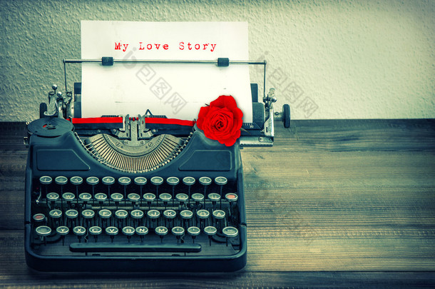 白皮书与红色玫瑰花的老式打字机。爱 St