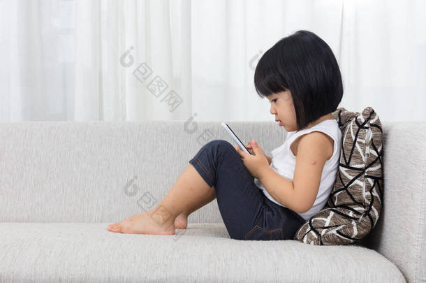 亚洲中国的小女孩躺在沙发上的<strong>手机</strong>