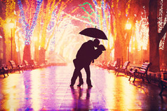 夫妇与伞接吻在夜晚小巷.