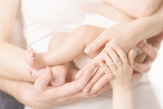 家庭手和婴儿新生儿脚，母亲父亲怀里，孩子们的身体拥抱新生孩子脚，家庭树概念