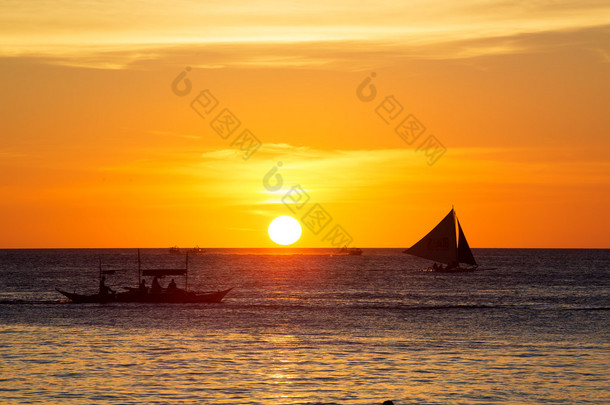 在日落时在热带<strong>海洋</strong>上的帆船。剪影照片.