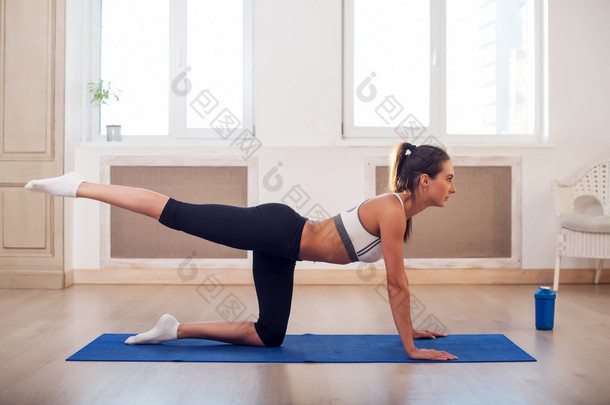 年轻活跃<strong>竞技</strong>运动苗条女人做瑜伽锻炼的健身房或家门前的 windows 伸展她的腿要回来