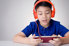 亚洲男孩洁具耳机和玩手机