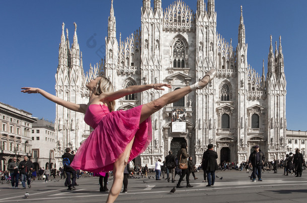 美丽的舞者穿着粉红色的连衣裙在米兰大教堂广场