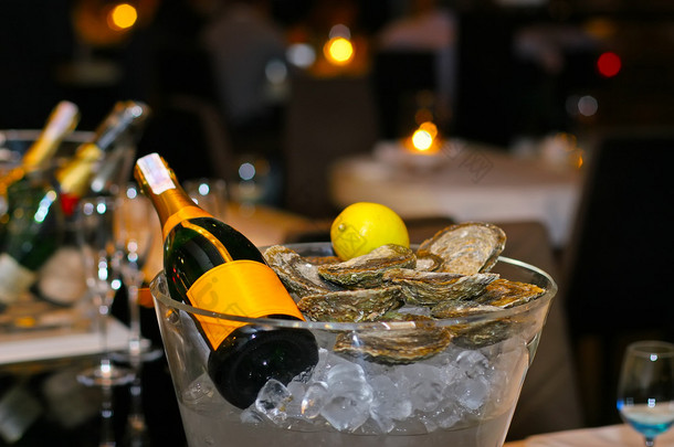 柠檬与新鲜牡蛎在冰桶里的香槟酒瓶
