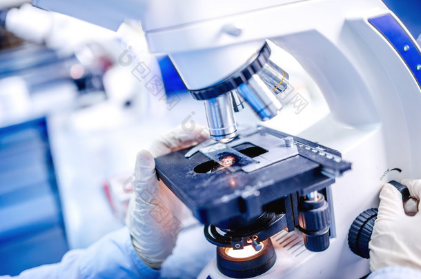 医学实验室的详细信息，使用化学生物显微镜的科学家手测试样品