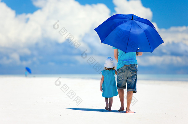 父亲和女儿在海滩散步