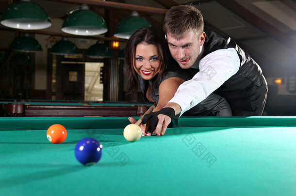 在昏暗的酒吧玩桌球一对夫妇的肖像