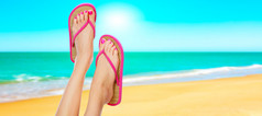 在女人的腿上的粉色凉鞋。夏季时间概念