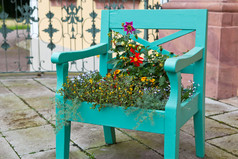 绿色的旧椅子用七彩花朵装饰