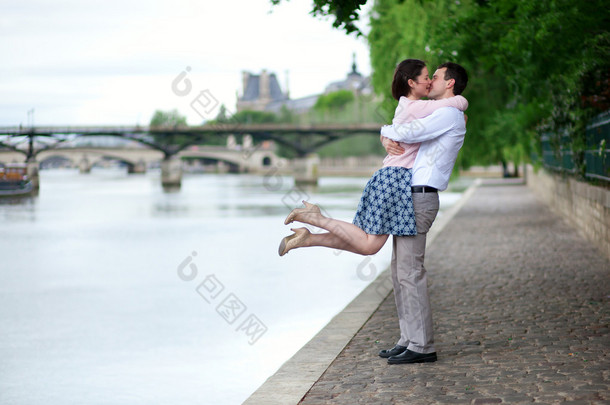 幸福浪漫情侣拥抱附近塞纳河，女孩跳跃