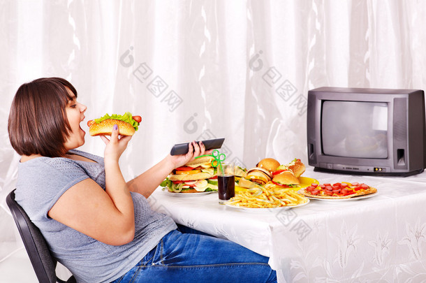 女人吃快餐和看电视.