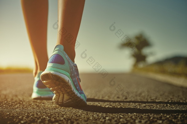 女子赛跑运动员特写剃去在日出或日落的道路上<strong>跑步</strong>的<strong>跑步</strong>鞋的脚