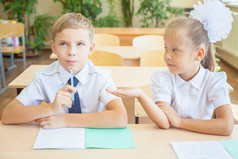 学生或同学在学校教室里一起坐在桌前