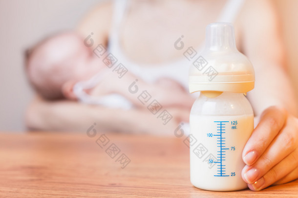 Mother holding a baby bottle with breast milk