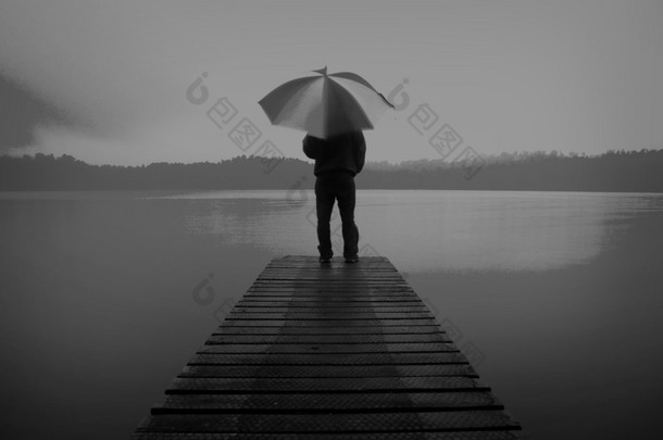 男子手持一把雨伞在湖概念