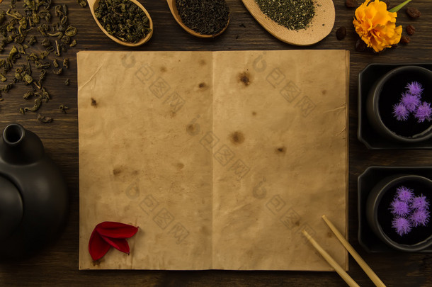 black, Oolong in a spoon, dried apples on the old blank open book on wooden background. Menu, recipe