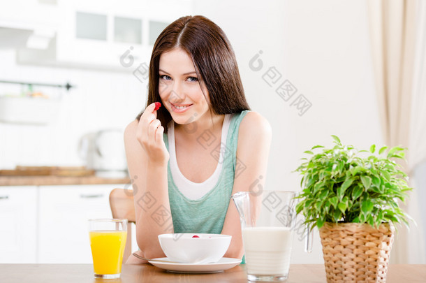 女人吃草莓的牛奶和橙汁