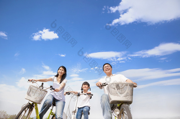 快乐家庭骑自行车与云背景
