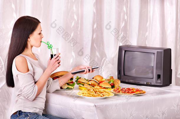 女人吃快餐和看电视.