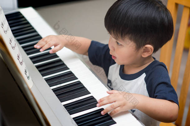 亚洲儿童弹<strong>钢琴</strong>在家里.
