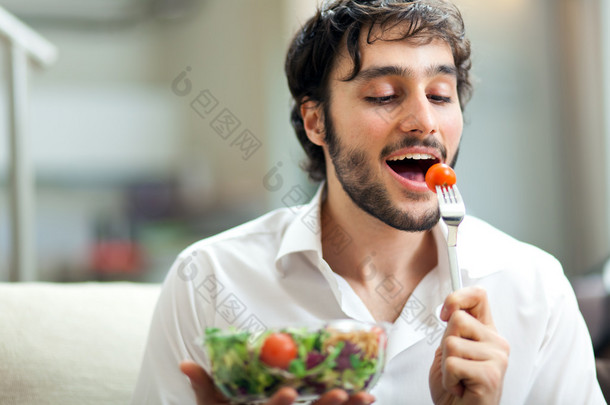 年轻男子吃健康的沙拉