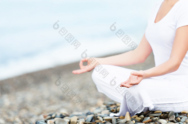 海滩上的瑜伽<strong>姿势</strong>打坐的女人的手