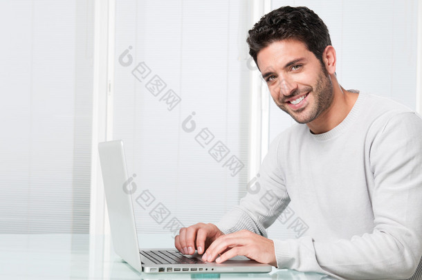 微笑在笔记本电脑上工作的人