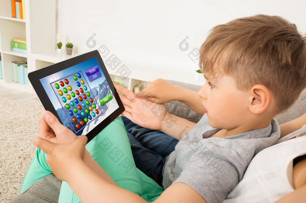 小孩在数字平板电脑上玩游戏