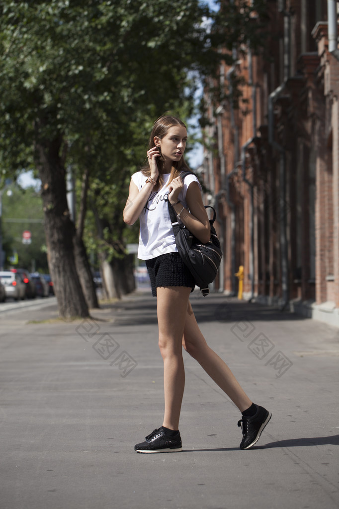 年轻漂亮的女人穿着蓝色的衣服走在夏天压力