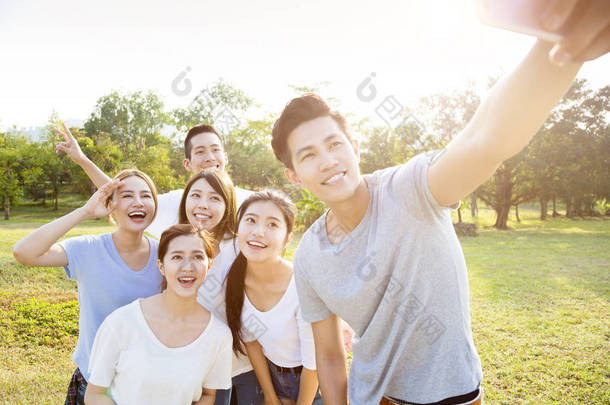 在公园里快乐的青年组以自拍照社区生活