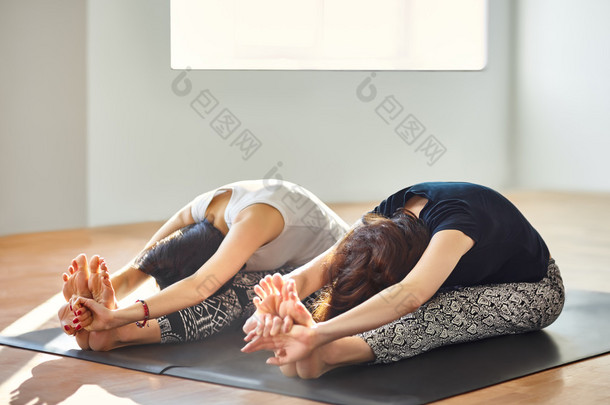 两个年轻女人<strong>做瑜伽</strong>体式坐前屈