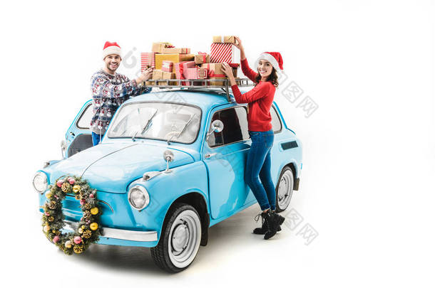  夫妇与圣诞节礼物在汽车屋顶