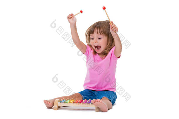 可爱的微笑开朗积极的女孩3岁的演奏<strong>乐器</strong>玩具木琴孤立在白色背景.