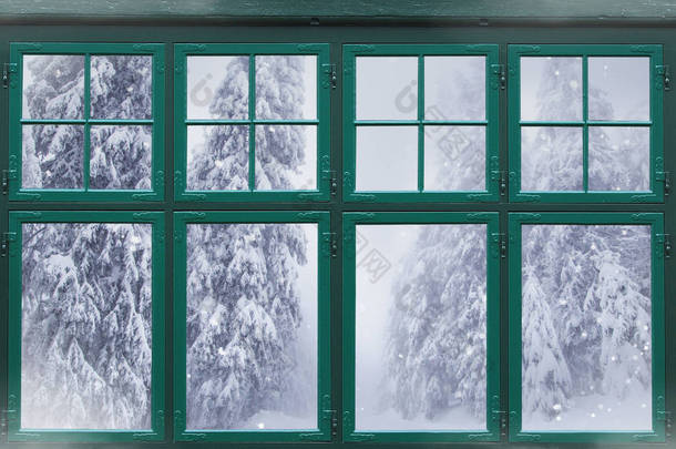 窗外的窗框，外面有白雪覆盖的冷杉树 