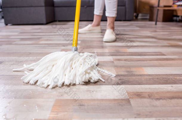 女人用拖把清洗地板