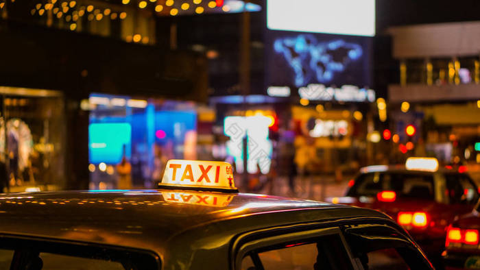出租车晚上的标志模糊视图在酒馆和酒吧夜生