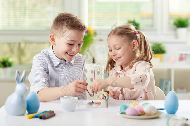 两个快乐的孩子们在复活节期间画鸡蛋玩乐
