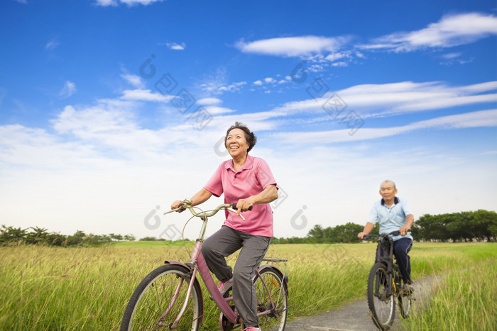 快乐亚洲老人老年人夫妇在农场骑自行车