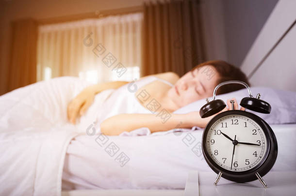 时钟显示 10 上午。和女人睡在床上与铁道部的阳光
