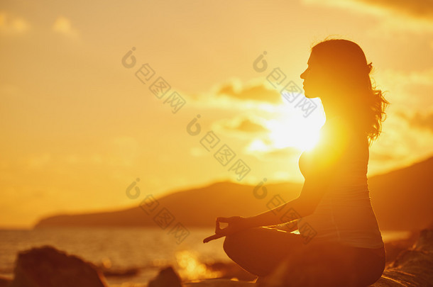 孕妇练瑜伽在荷花在阳光沙滩上的立场