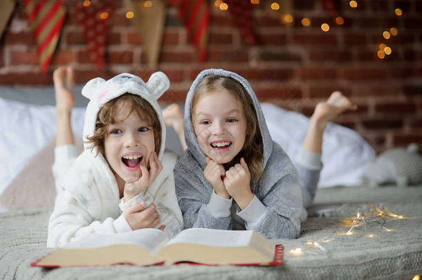 两个孩子，弟弟和妹妹，读圣诞故事.