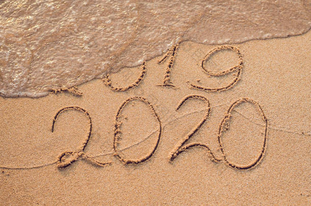 新年<strong>2020</strong>是未来概念-题字2019和<strong>2020</strong>沙滩沙子, 波浪几乎覆盖数字2019.