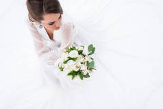 年轻新娘在礼服举行婚礼花束, 在白色孤立的开销视图