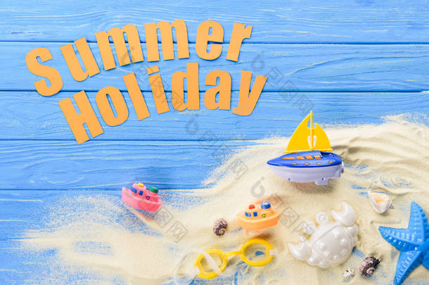 沙滩玩具在蓝色<strong>木质背景</strong>下的夏日假期题词
